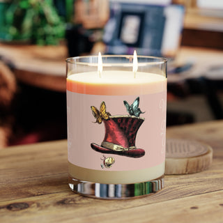 'Whispers of the Dream Granter' candle with a decorative label featuring a top hat and butterflies on a wooden surface.